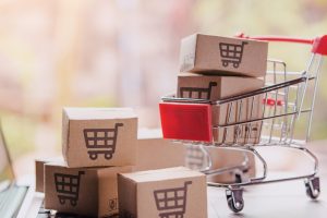Shopping online concept - Parcel or Paper cartons with a shopping cart logo in a trolley on a laptop keyboard. Shopping service on The online web. offers home delivery.
